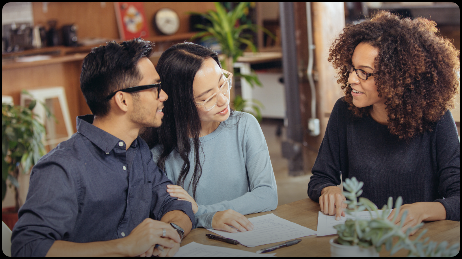 A car salesperson reviewing paperwork with two buyers